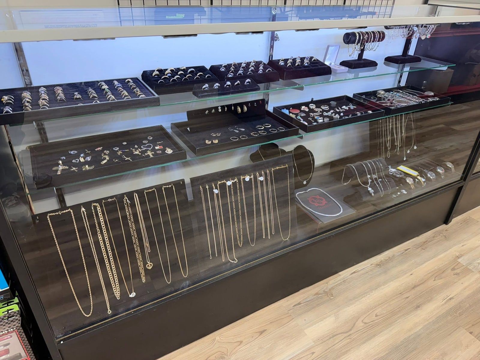 Glass display case of gold and silver rings, earrings, pendants, and chains at New Georgia Pawn