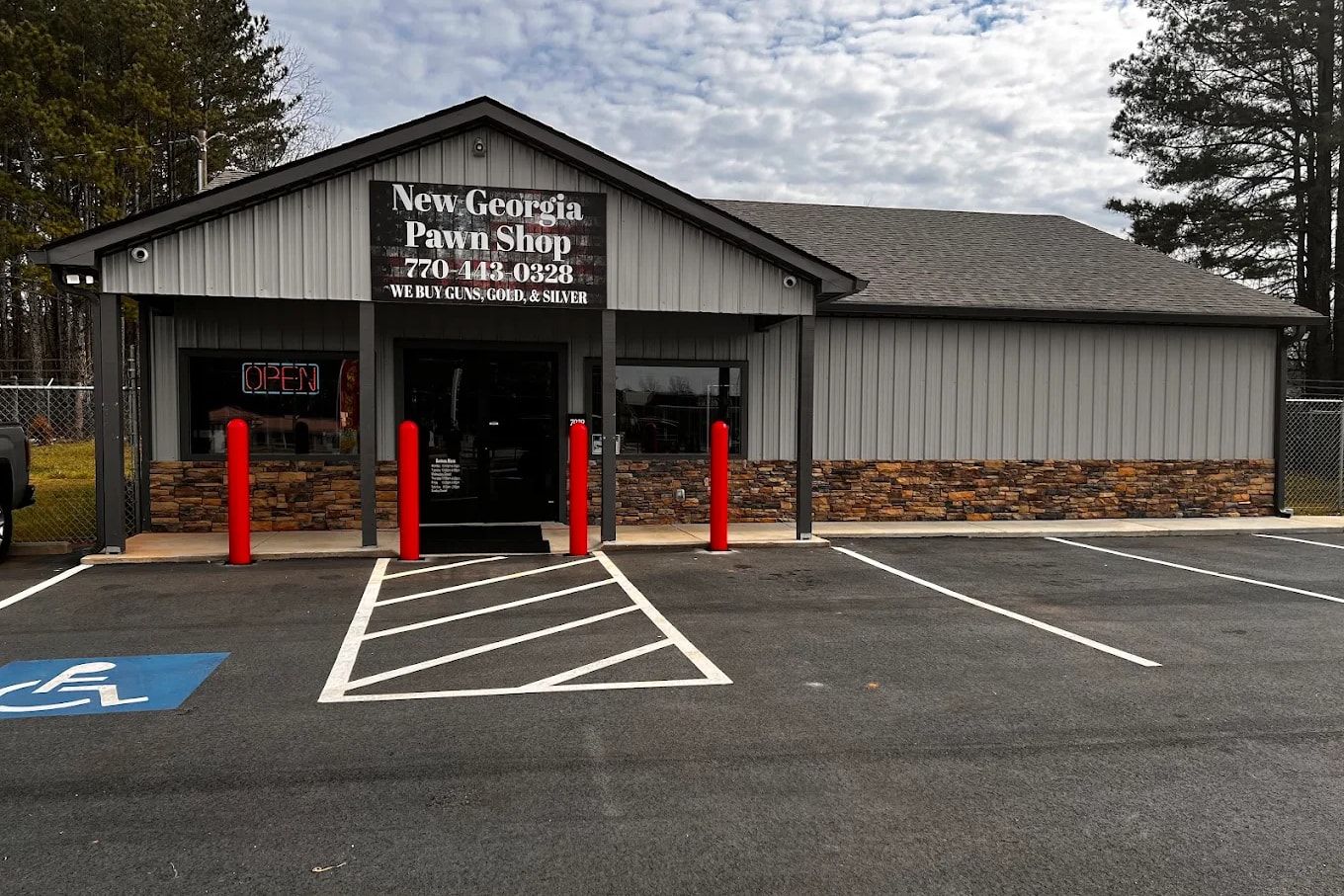 The New Georgia Pawn Shop storefront on Villa Rica Highway in Dallas, GA: a gray metal building with a stone base and the shop sign over the door